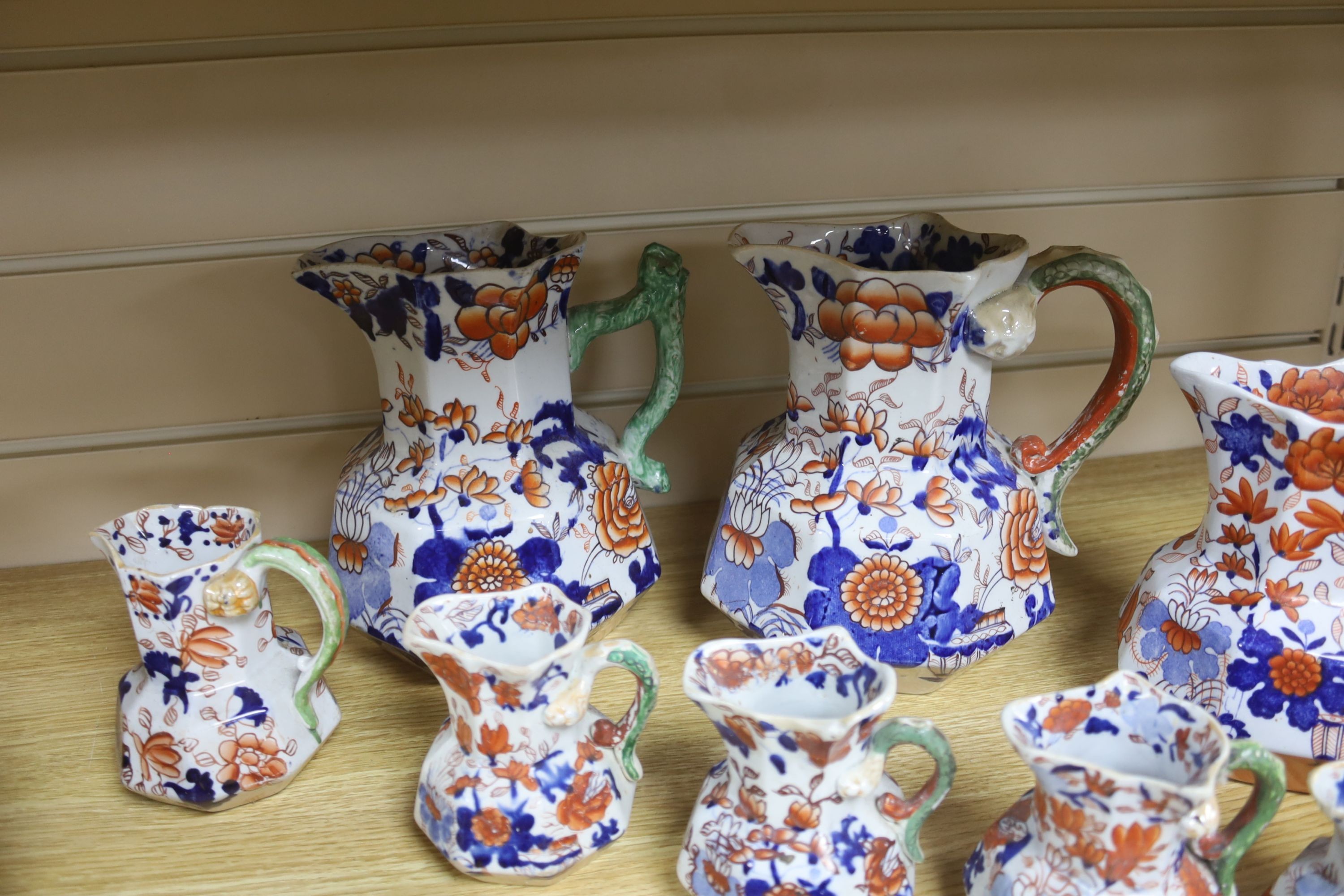 A graduated set of eight Mason's floral Imari pattern ironstone hydra jugs, c.1820-30, largest 19cm smallest 7cm and two other Mason’s ironstone jugs (10)